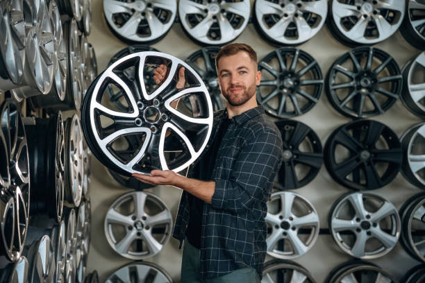 istock Brand new disk. Man worker is maintenance station with tires, wheels 2187818104