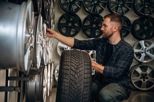 istock Sitting, professional man worker is maintenance station with tires, wheels 2187818325