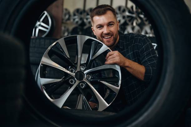 istock Brand new disk. Man worker is maintenance station with tires, wheels 2187818576