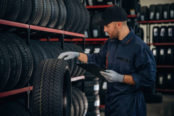 istock Black colored notepad, information, documents. Man worker is maintenance station with tires, wheels 2187819096