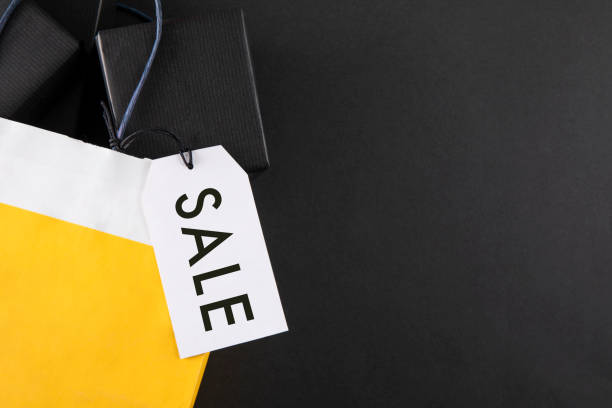 Black friday shopping bag with gift boxes on black colored background