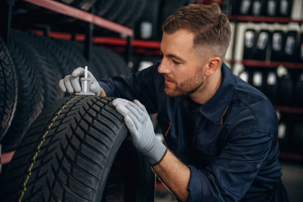 istock Tool for measuring. Man worker is maintenance station with tires, wheels 2187819824