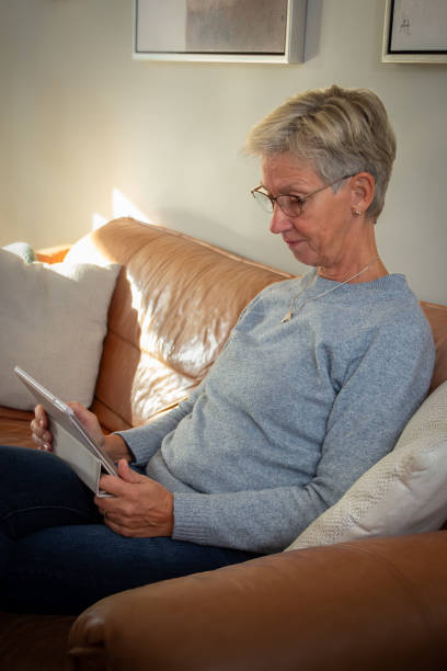istock Mature woman with a tablet in a couch 2187826429