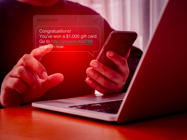 istock SMS spam, fake text message phishing from scammer concept. Spam text messages, Winning congratulations phishing text with link tracking, on message alert display on mobile phone screen in person hand. 2187827124
