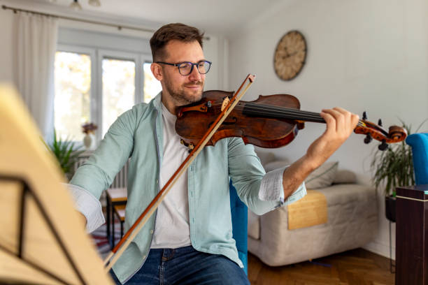 istock Man Playing Violin in Cozy Living Room Setting with Focus 2187829558