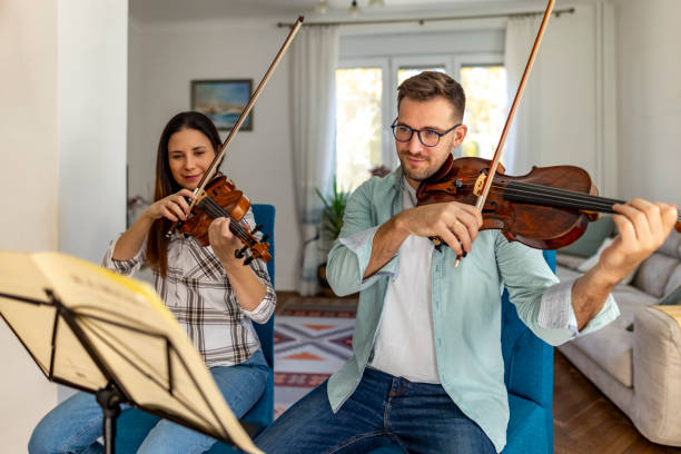 istock Two People Playing Violins Together in a Cozy Home Setting 2187829812