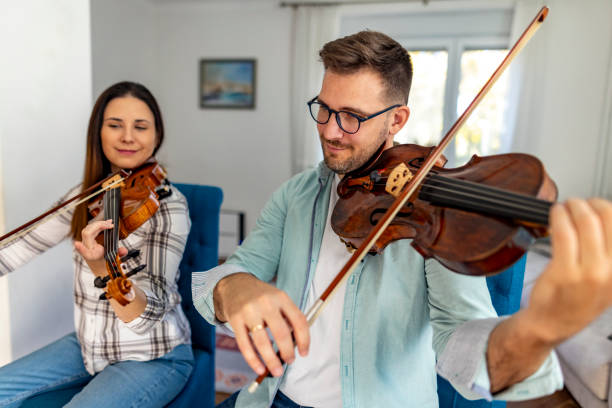istock Two Musicians Practicing Violin Together in a Bright Living Room 2187829814