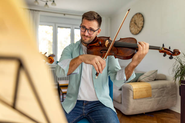 istock Man Playing Violin In Living Room During Daytime Practice Session 2187830149