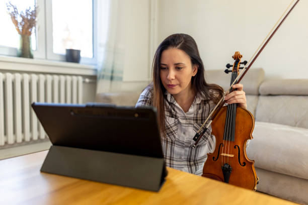 istock Woman Learning Violin Online via Tablet in Cozy Home Setting 2187830179