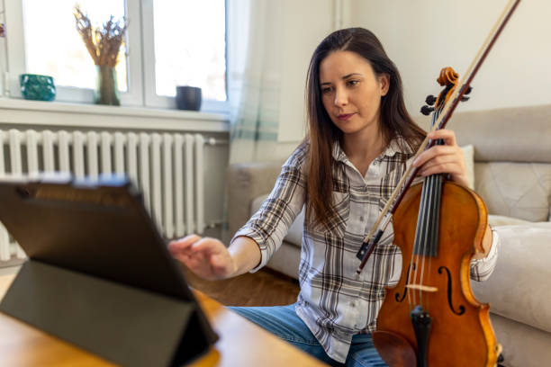 Woman Learning Violin with Online Resources on a Tablet at Home