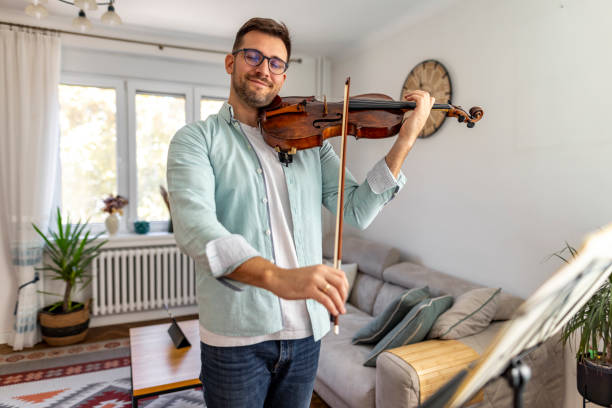 istock Man Playing Violin in a Cozy Living Room Setting 2187830695