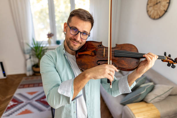 istock Man Playing Violin in Cozy Living Room Interior Setting 2187830723