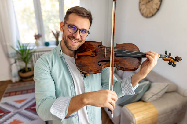 istock Smiling Man Playing Violin in Cozy Living Room Setting 2187831663