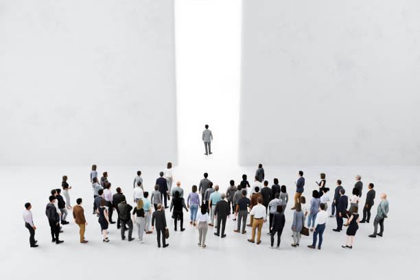 People follow their leader approaching bright light in large wall