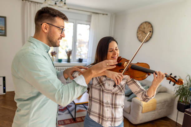 istock Music Instructor Teaching Violin to Student in a Cozy Living Room 2187831799