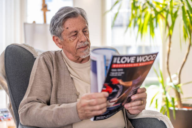 istock Relaxed Senior Man Reading a Magazine at Home 2187835477