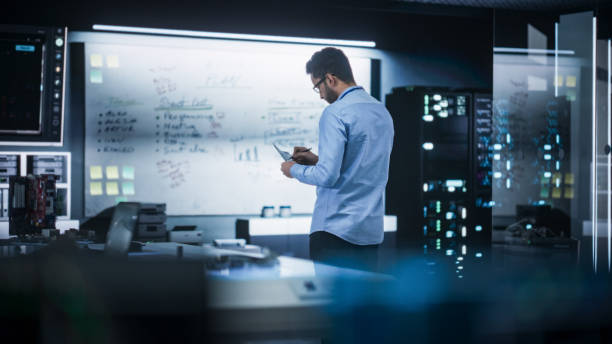 istock Portrait of a Male Specialist Working in a Technological Startup Taking Notes from the White Board in Office. Professional Data Analyst Collecting Information for Project Development 2187841713