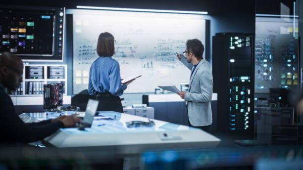 istock In Technological Research Facility: Portrait of a Team of Two Professional Engineers Using Digital Tablet and White Board to Discuss the Manufacturing Plan for Product Development 2187841776