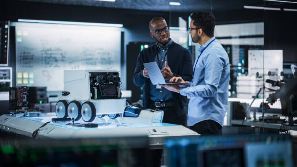 istock Portrait of Two Diverse Male Engineers Developing a Remotely Controlled Robot in an Industrial Research Facility. Specialists Using Laptop Computer, Working on Machine Improvement, Brainstorming 2187842582