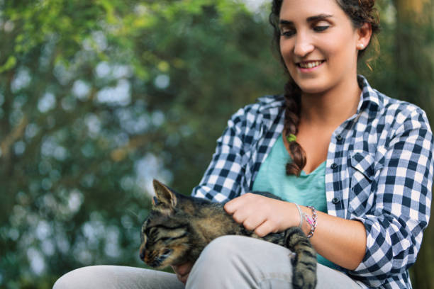 istock Young woman cuddling her cat in a forest 2187843000