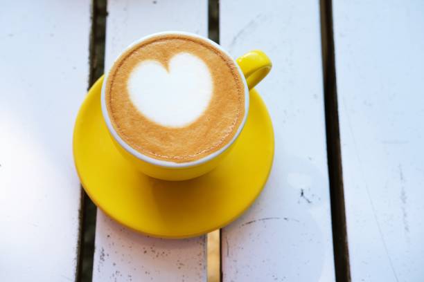 istock A vibrant yellow cup of latte art on a white table. 2187848095