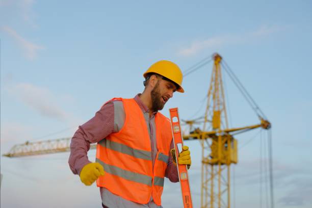 istock Construction worker wearing safety vest and holding spirit level at construction site 2187850792