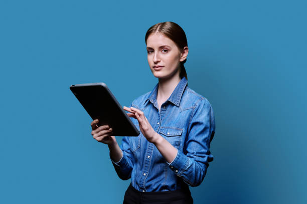 istock Teenager student girl with digital tablet on blue studio background 2187851454