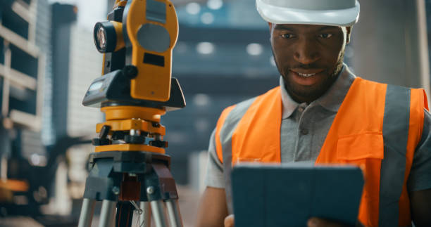 istock African American Architect Working as a Civil Engineer. Young Black Man Using Optical Total Station Theodolite for Planning and Surveying the Construction of a Commercial Real Estate Building 2187851495