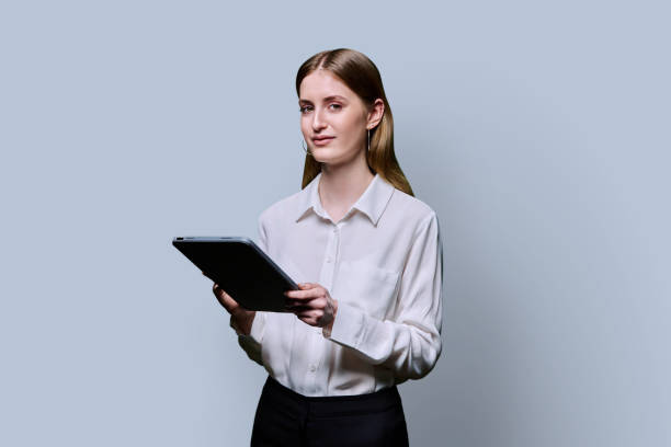istock Teenager student girl with digital tablet on grey studio background 2187851501