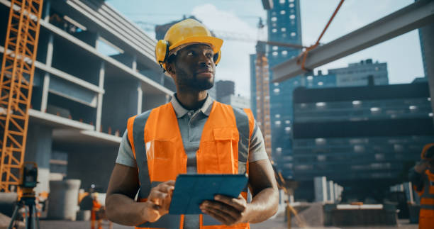 istock Portrait of a Handsome Black Civil Engineer Working on a Tablet at a Construction Site. Young African Man Standing Outdoors, Using Computer Device for Planning and Developing a Real Estate Project 2187852204