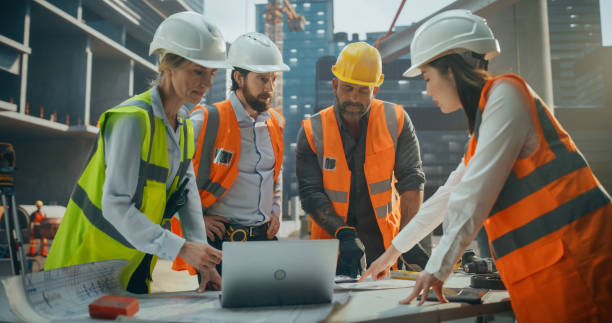 istock Diverse Multiethnic Team of Construction Workers Having a Meeting Outdoors at a Building Site. Male and Female Infrastructure Company Crew Discussing Office Building Development Plans 2187852459