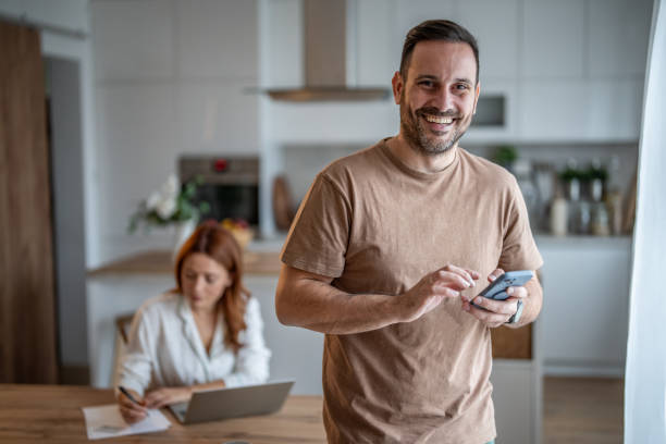 Digital dynamics - Man in focus with phone, wife in background with laptop
