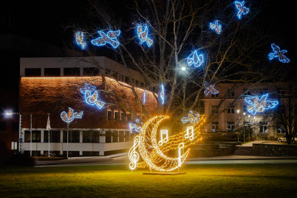 istock A glowing musical light display with notes, treble clef, and blue dove decorations in a city park at night, creating a festive ambiance. 2187856801