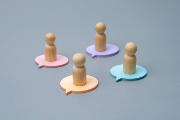 istock Four wooden figures, each standing on a differently colored speech bubble. 2187859364