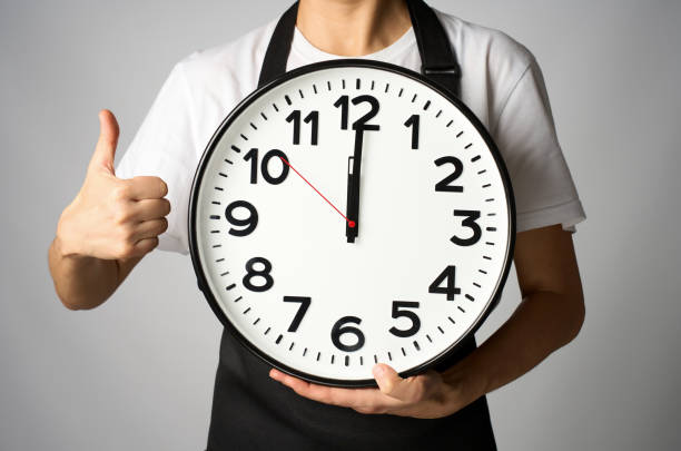 istock Cooking deadline concept. Woman chef in apron holding clock, white background with copy space 2187859762