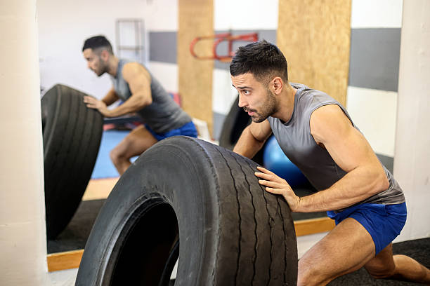 Young man exercising with a tire. About 30 years old, Caucasian male.