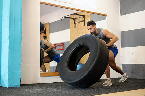 Young man exercising with a tire. About 30 years old, Caucasian male.