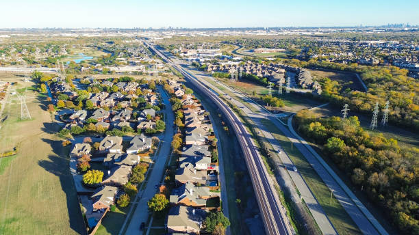 istock Fast growing mixed-use development area with residential houses, light rail system, precast concrete walls noise barrier along Belt Line Road suburbs Dallas, sound mitigation city quiet zones 2187862131