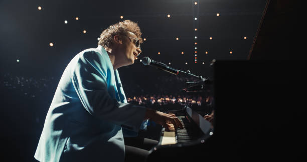 istock Young Charismatic Pianist Playing and Singing, Performing an Experimental Fusion Jazz Compositions on Stage. Grand Piano Reacts to His Soulful Tunes, Leaving Excited Audience in Awe 2187864159