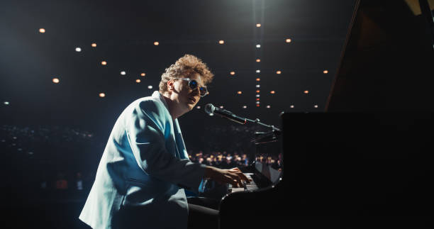 istock Young Charismatic Pianist Playing and Singing, Performing an Experimental Fusion Jazz Compositions on Stage. Grand Piano Reacts to His Soulful Tunes, Leaving Excited Audience in Awe 2187864203