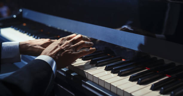 istock Close Up on Hands of a Talented Anonymous Pianist Making a Masterful Performance on a Grand Piano. Under Soft Stage Lights, His Fingers Move Across the Keys, Creating Beautiful Classical Music 2187864943