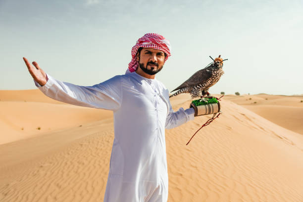 istock arab man with falcon in the desert 2187865401