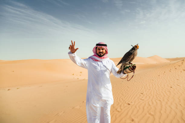 istock arab man with falcon in the desert 2187865443