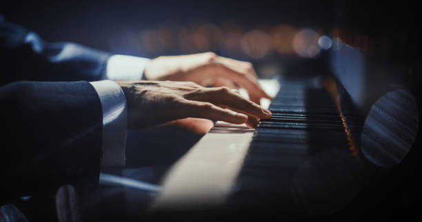 istock Close Up on Hands of a Talented Anonymous Pianist Making a Masterful Performance on a Grand Piano. Under Soft Stage Lights, His Fingers Move Across the Keys, Creating Beautiful Classical Music 2187865524