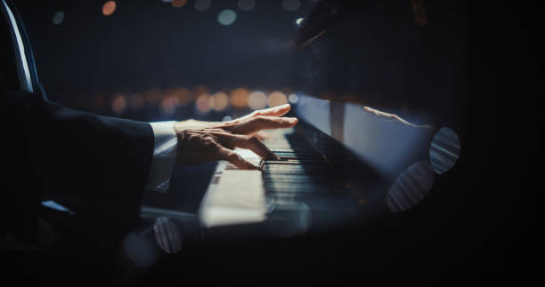 istock Close Up on Hands of a Talented Anonymous Pianist Making a Masterful Performance on a Grand Piano. Under Soft Stage Lights, His Fingers Move Across the Keys, Creating Beautiful Classical Music 2187865575