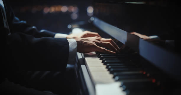 istock Close Up on Pianist Hands Playing a Mesmerizing Jazz Melody on a Black Grand Piano. Anonymous Artist is Focused on Creating Beautiful Instrumental Sonata as He Plays on Stage for the Audience 2187865614