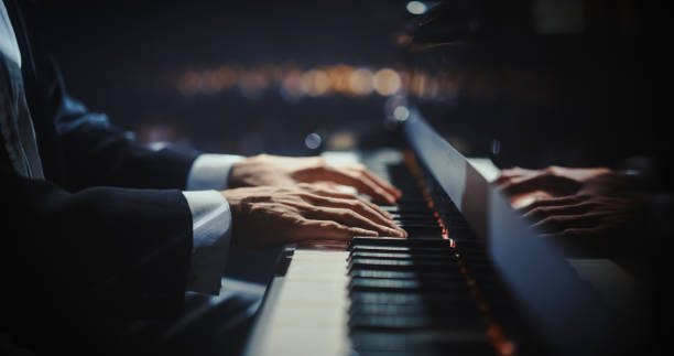 istock Close Up on Hands of a Talented Anonymous Pianist Making a Masterful Performance on a Grand Piano. Under Soft Stage Lights, His Fingers Move Across the Keys, Creating Beautiful Classical Music 2187865628