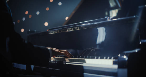 istock Close Up on Hands of a Talented Anonymous Pianist Making a Masterful Performance on a Grand Piano. Under Soft Stage Lights, His Fingers Move Across the Keys, Creating Beautiful Classical Music 2187865731