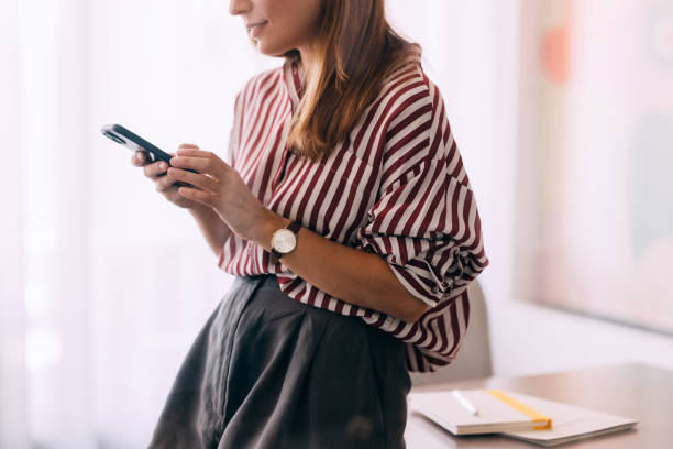 Woman Texting on Smartphone in Modern Office Environment