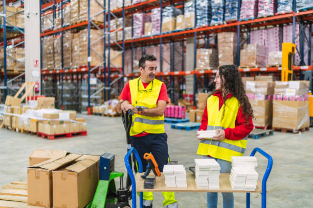 istock Warehouse workers organizing packages for delivery using a hand pallet truck 2187866230